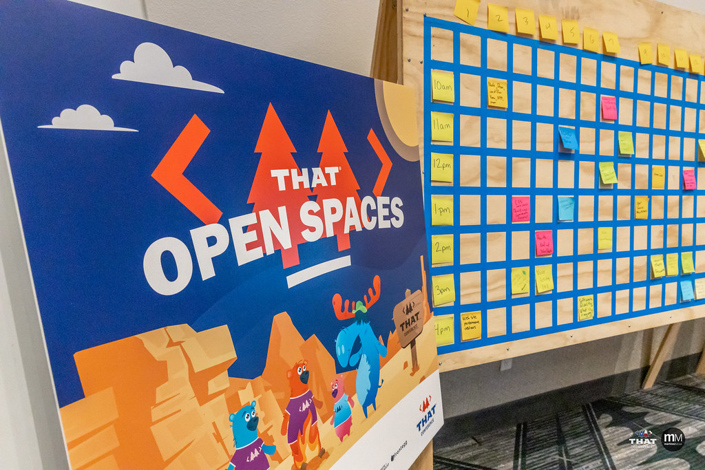 A sign board that says, "THAT open spaces", next to a large grid of time slots and table numbers for people to reserve an open space.